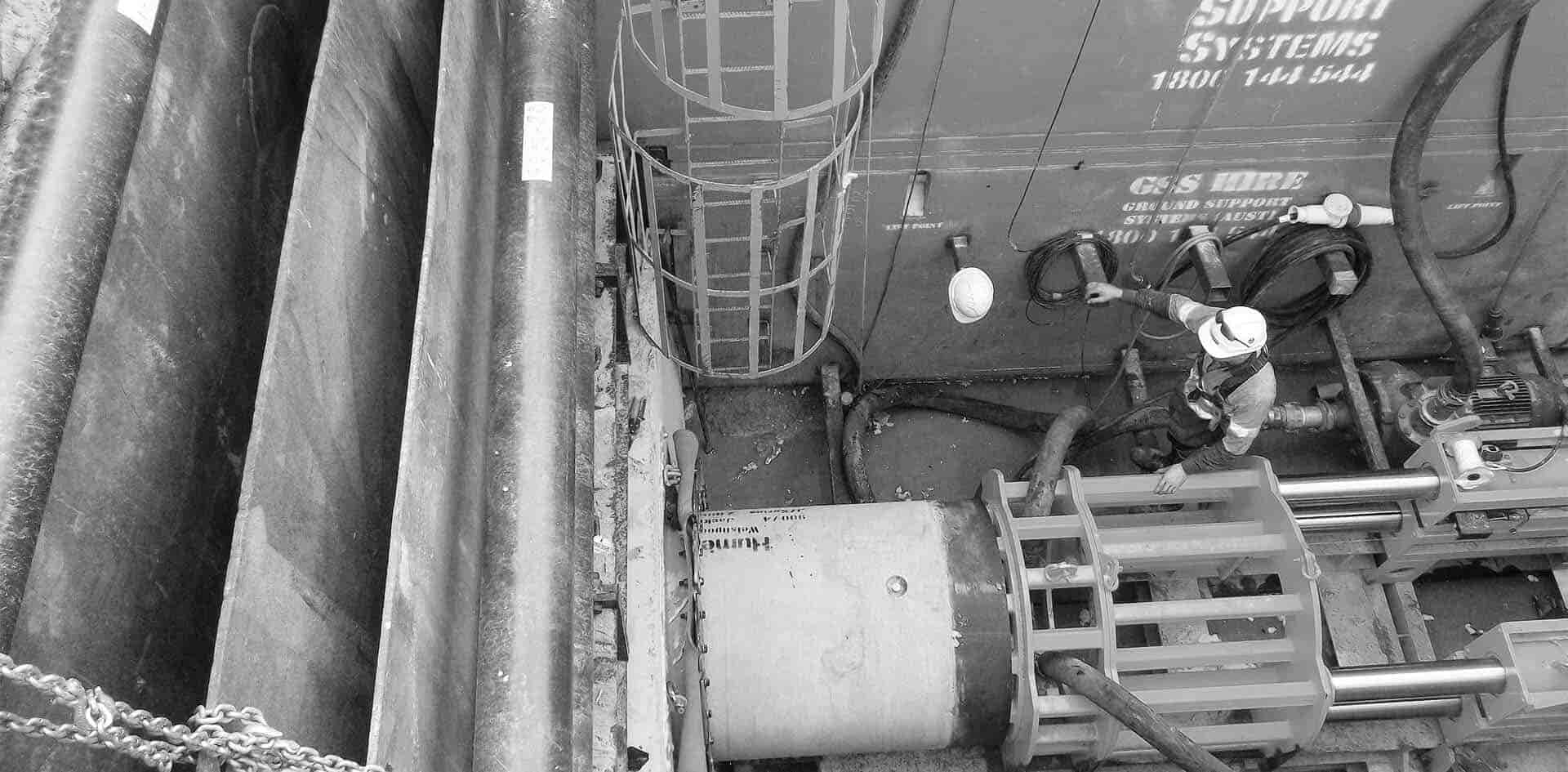 An image from above of man next to tunneling machine.